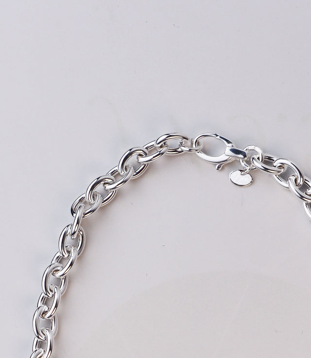 Bred silverkedja med ovala länkar och lås.