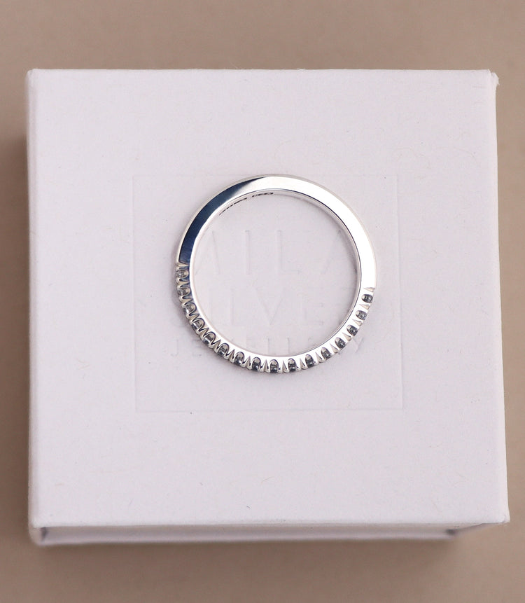 diamantring sedd uppifrån där man ser diamanternas infattning i kronor. Ringen är en silverring med raka kanter, halva ringen är infattad med diamanter. 