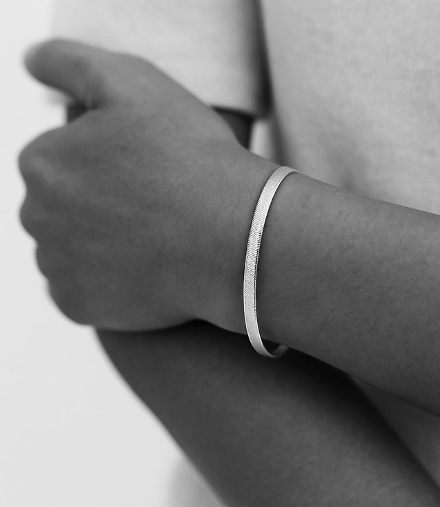 tjej som bär ett silverarmband med platt snake kedja. 