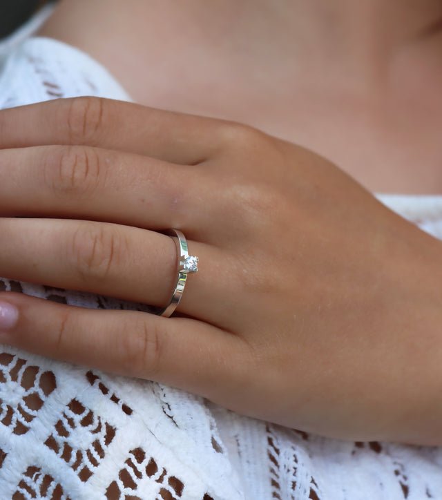 Tjej som bär en Vigsel eller Förlovningsring i silver med 0,10 ct diamant i fyrkantig fattning. 