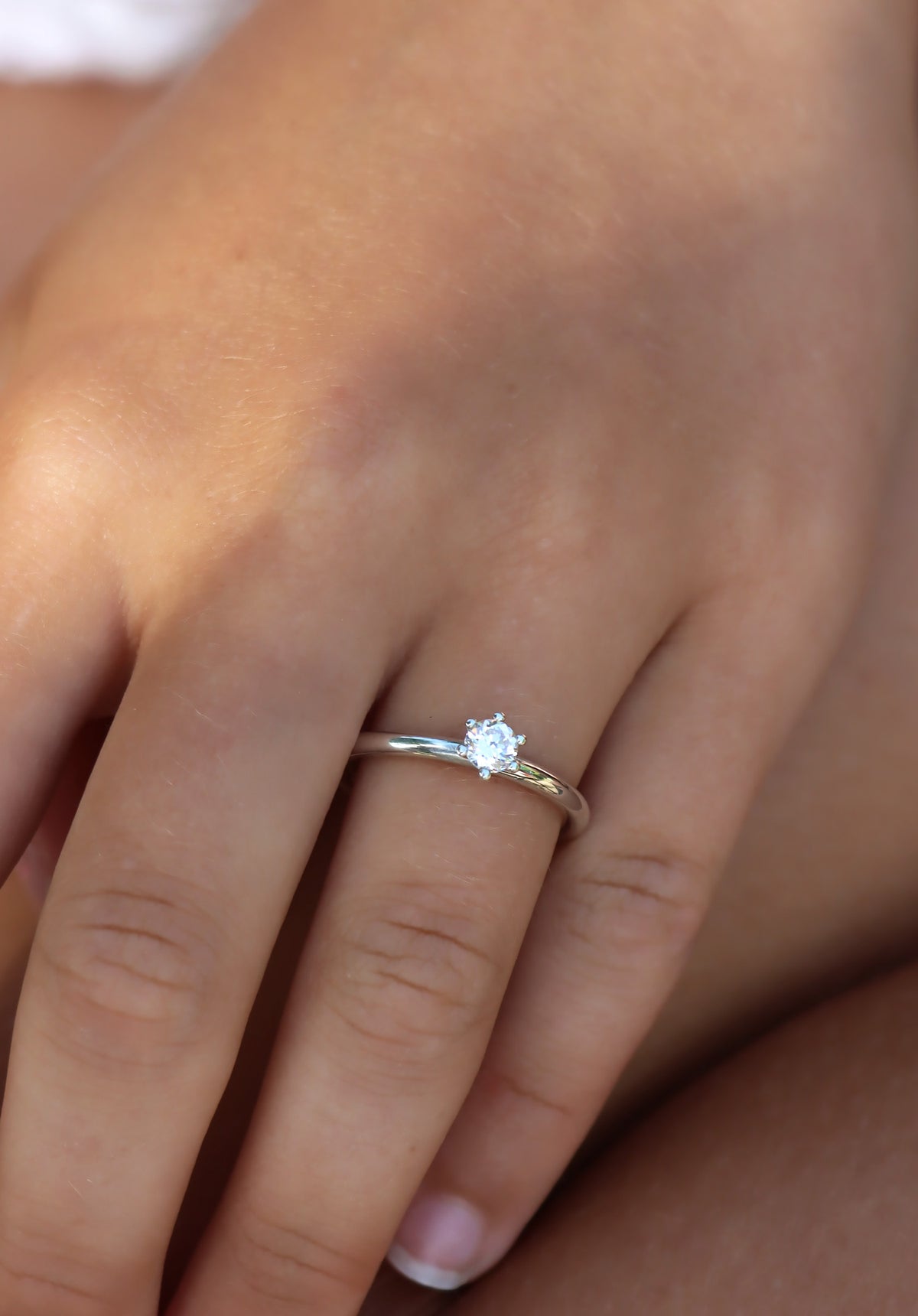 Tjej som bär en vigsel- eller förlovningsring med 0,25 ct briljantslipad diamant. 