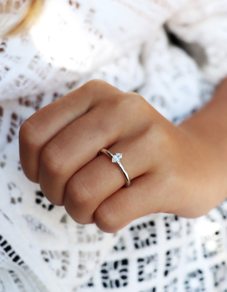 Tjej som bär en diamantring i silver med oval diamant som vigsel eller förlovningsring. 