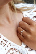 Tjej som bär en diamantring i silver med oval diamant som vigsel eller förlovningsring. 