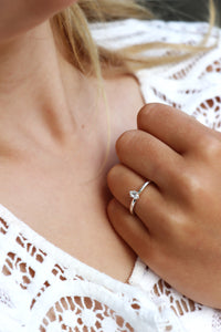 Tjej som bär en diamantring i silver med oval diamant som vigsel eller förlovningsring. 