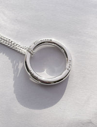 Halsband med silverring som har tre namn graverade