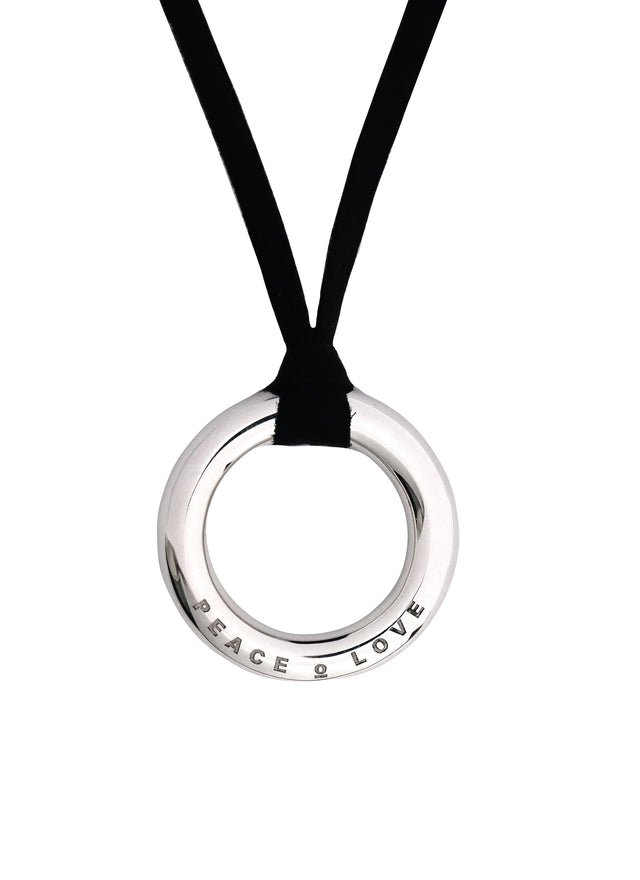 Halsband med silverring som har graverad text på framsidan av ringen. Ringen hänger i ett svart läderband. 