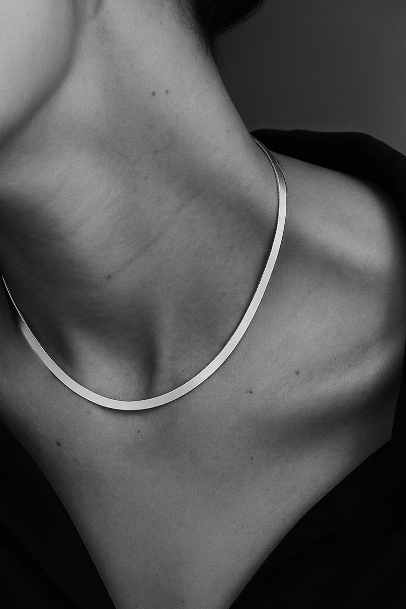 halsband med platt silverkedja som är kort. 