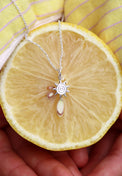 Silverhalsband med en liten sol placerad på en citron. 