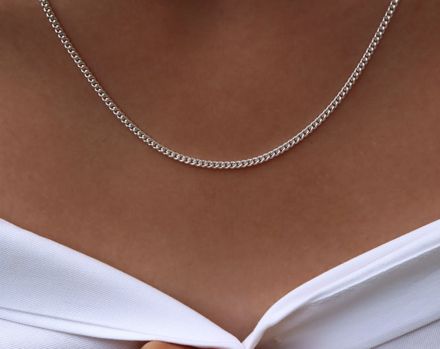 Kvinna som bär ett halsband med pansarkedja i silver. 2 mm bred, 45 cm lång. 