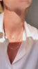 Tjej som bär ett kort diamanthalsband kombinerat med tunna kedjor - layering. 