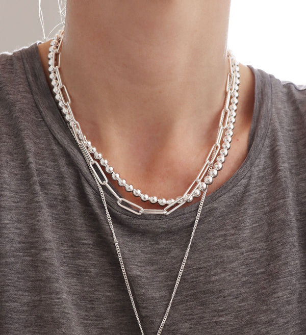 Halsband med ett band av silverkulor kombinerat med silverkedjor. 