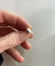 Närbild på ett litet silverhjärta som har kantig form.