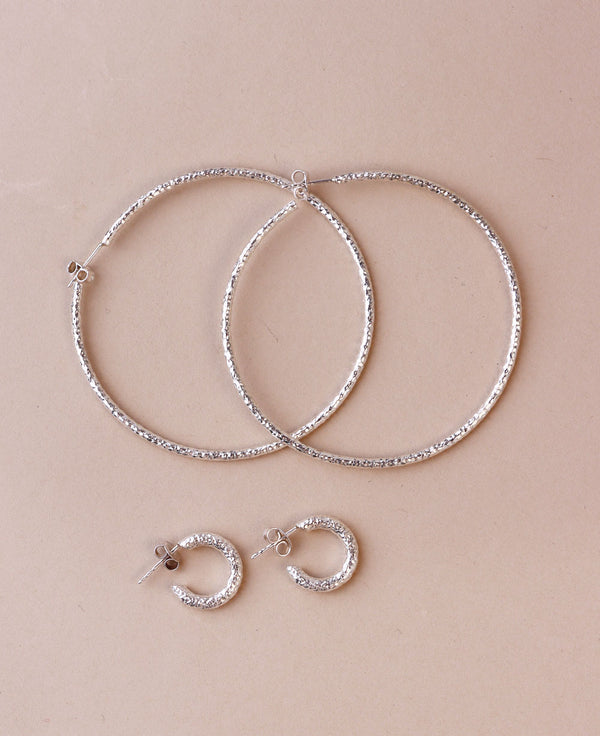 Silverörhängen med ringar som är hamrade. 